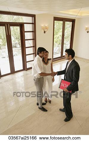 Stock Photograph - agent with young couple. Fotosearch