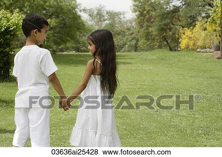 boy and girl holding hands in park View Large Photo Image Stock Photo - boy and girl holding hands in park. Fotosearch