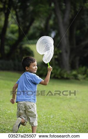 Stock Photo - boy chasing butterflies with net. Fotosearch