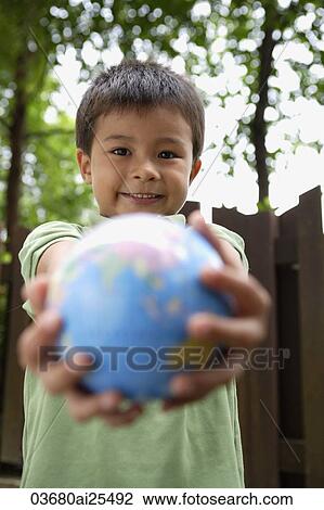 Stock Image - Boy holding out globe. Fotosearch
