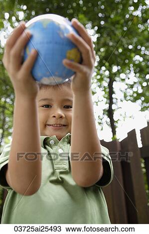 Stock Image - Boy holding up globe. Fotosearch