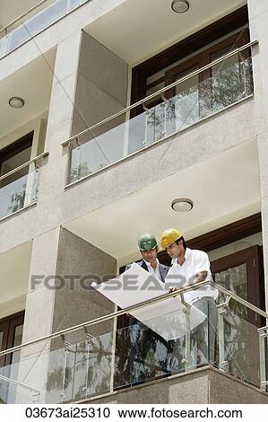 Stock Image - contractors or architects with blueprints. Fotosearch
