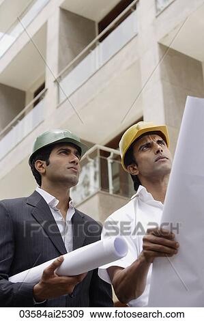 Stock Photo - contractors or architects with blueprints. Fotosearch