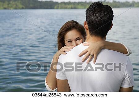 Couple embracing near lake View Large Photo Image Stock Image - Couple embracing near lake. Fotosearch