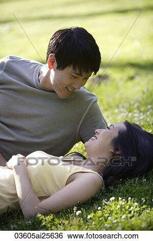 Couple lying in grass View Large Photo Image Stock Photograph - Couple lying in grass. Fotosearch