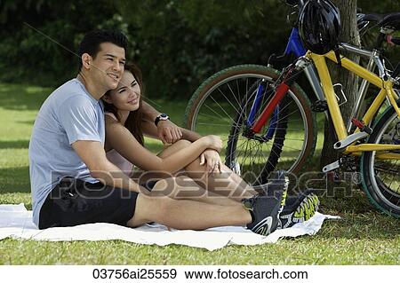 Couple resting on blanket in a park View Large Photo Image Stock Photo - Couple resting on blanket in a park. Fotosearch