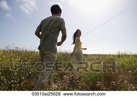 Stock Photo - Couple walking in field. Fotosearch