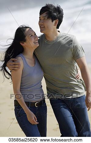 Stock Image - Couple walking on beach. Fotosearch