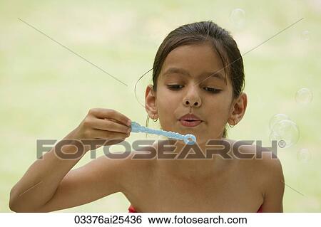 Stock Photograph - girl blowing bubbles. Fotosearch