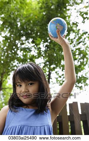Stock Image - Girl holding up globe. Fotosearch