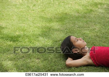 Stock Image - girl lying on back in grass. Fotosearch