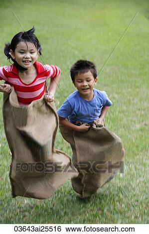 Stock Photograph - Kids having sack race. Fotosearch
