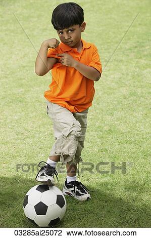 little boy flexing muscle, foot on ball View Large Photo Image Stock Image - little boy flexing muscle, foot on ball. Fotosearch