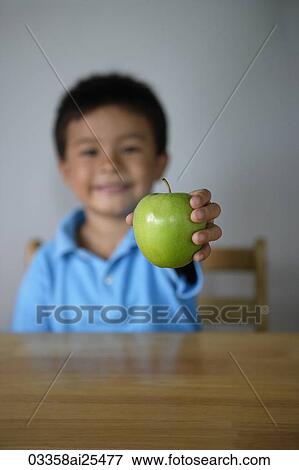 Stock Photo - Little boy holding green apple. Fotosearch