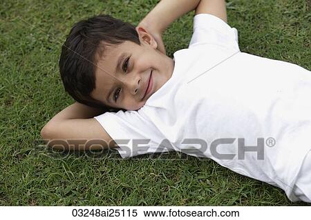 Little boy lying on back in park View Large Photo Image Stock Photography - Little boy lying on back in park. Fotosearch