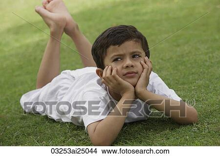 Picture - Little boy relaxing in park. Fotosearch