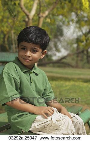Little boy sitting on park bench View Large Photo Image Stock Photo - Little boy sitting on park bench. Fotosearch