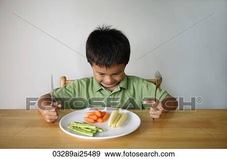 Stock Photo - Little boy with plate of vegetables. Fotosearch