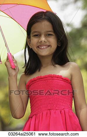 Little girl in pink dress standing under umbrella View Large Photo Image Stock Image - Little girl in pink dress standing under umbrella. Fotosearch