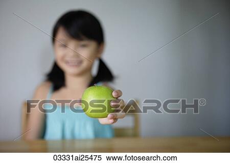 Little girl offering green apple View Large Photo Image Stock Photography - Little girl offering green apple. Fotosearch