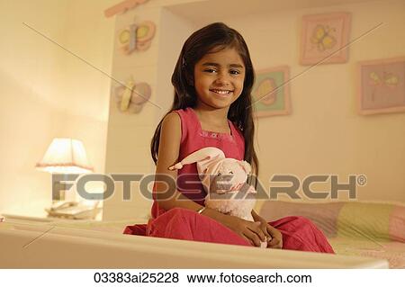 Stock Photo - little girl on bed with teddy bear. Fotosearch