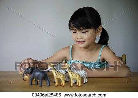 Stock Photograph - Little girl playing with animals. Fotosearch