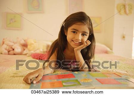 little girl reading book on bed View Large Photo Image Stock Photo - little girl reading book on bed. Fotosearch