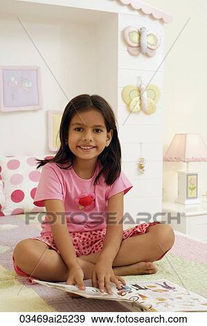 Stock Photo - little girl reading on bed. Fotosearch