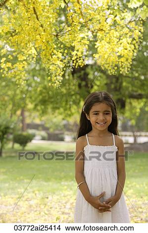 little girl standing under tree View Large Photo Image Picture - little girl standing under tree. Fotosearch
