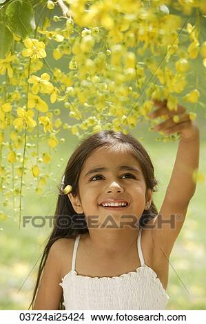 Picture - little girl under flowering tree. Fotosearch