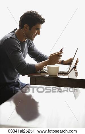 Stock Image - man at laptop looking at text messages. Fotosearch