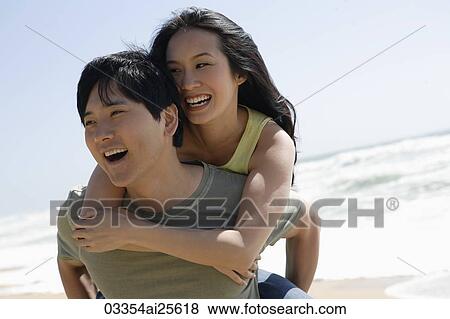 Man carrying woman on beach View Large Photo Image Stock Photo - Man carrying woman on beach. Fotosearch
