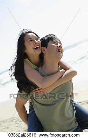 Stock Photograph - Man carrying woman on his back. Fotosearch