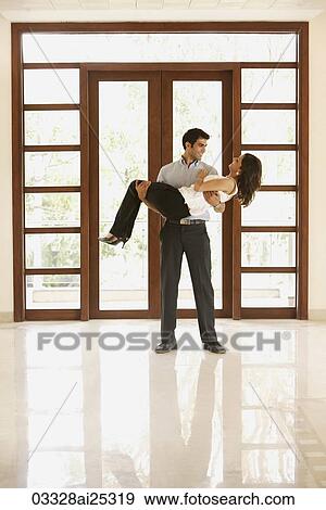 Stock Photo - man carrying woman over threshold into empty home. Fotosearch