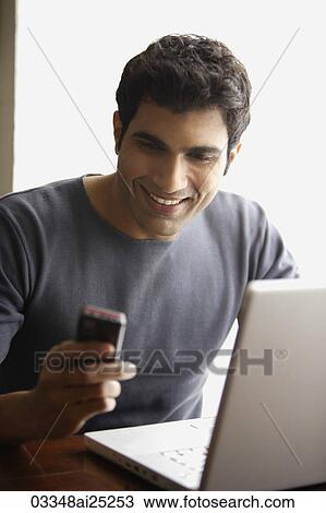 Stock Image - man looking at text messages. Fotosearch