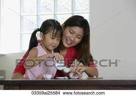 Picture - Mother and daughter having tea party. Fotosearch