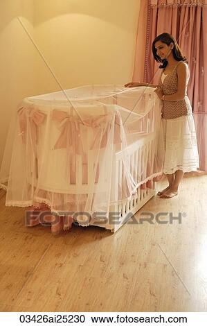 mother looking into baby crib View Large Photo Image Stock Image - mother looking into baby crib. Fotosearch