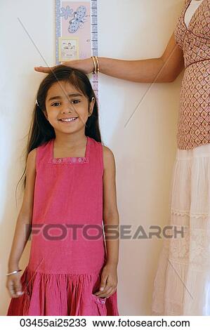 mother measuring daughter's height View Large Photo Image Stock Image - mother measuring daughter's height. Fotosearch