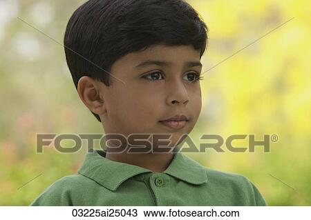 Stock Image - serious little boy wearing green shirt. Fotosearch