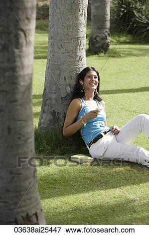 Stock Photo - teen girl listening to music in park. Fotosearch