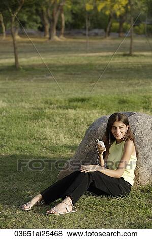 Stock Photo - teen girl listening to music in park. Fotosearch