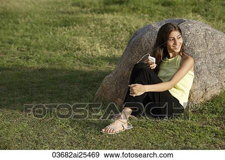 Stock Photo - teen girl listening to music in park. Fotosearch