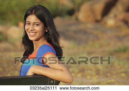 Stock Image - Teen girl on park bench. Fotosearch