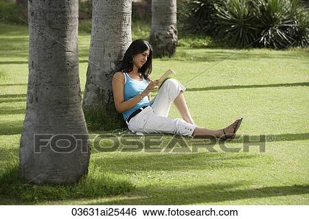 Stock Photograph - teen girl reading book in park. Fotosearch
