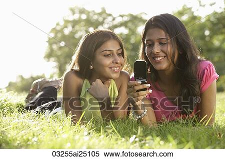 Stock Photography - Teen girls reading text messages. Fotosearch