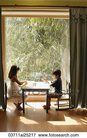 Stock Photo - two children playing at table. Fotosearch