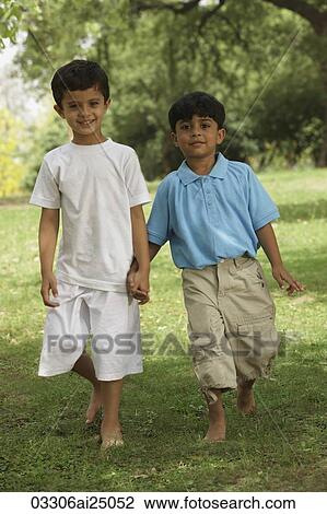 Stock Image - two little boys holding hands in a park. Fotosearch