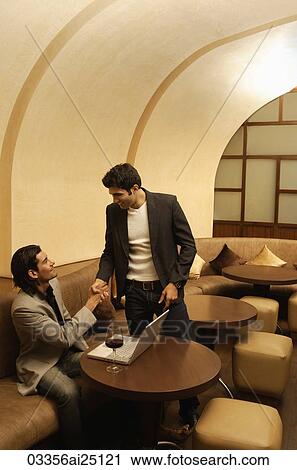 Stock Image - two men shaking hands. Fotosearch