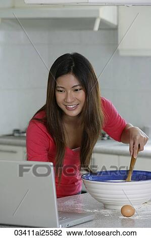 Woman reading recipe on laptop View Large Photo Image Stock Image - Woman reading recipe on laptop. Fotosearch