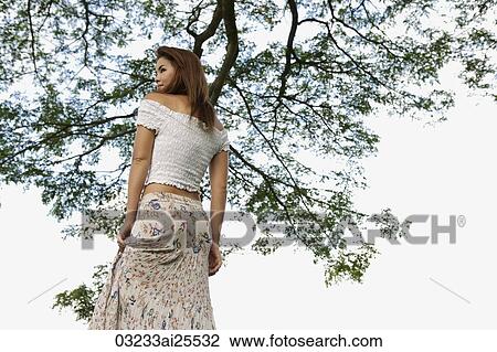 Woman standing under tree View Large Photo Image Stock Image - Woman standing under tree. Fotosearch